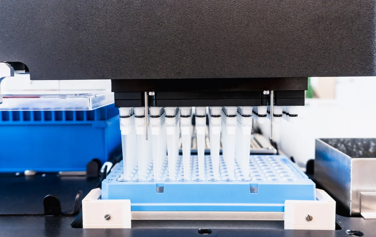 Automated laboratory pipetting equipment with multiple dispensing heads and sample trays.